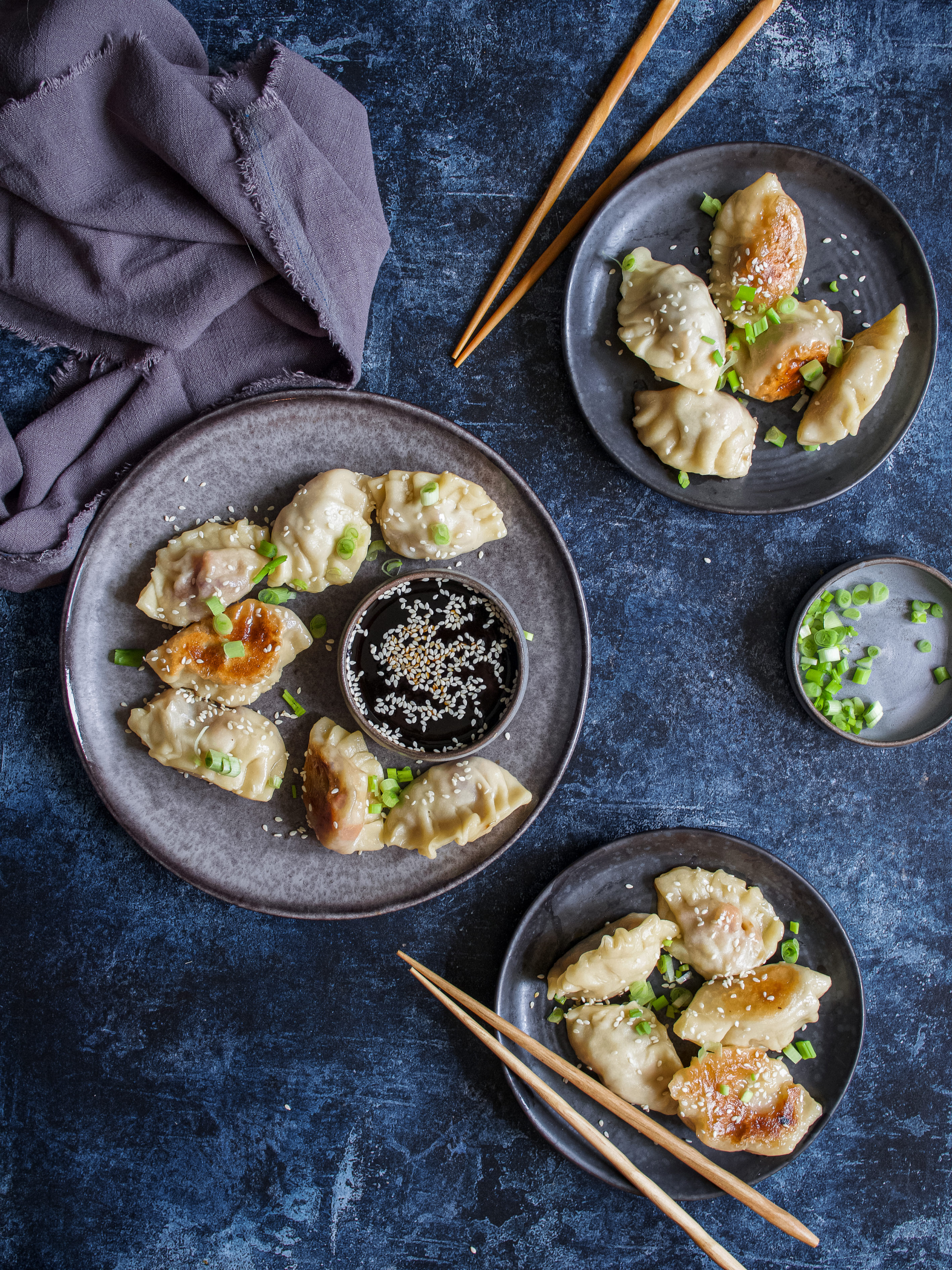 des raviolis japonais avec de la sauce soja, de la ciboule et du sésame