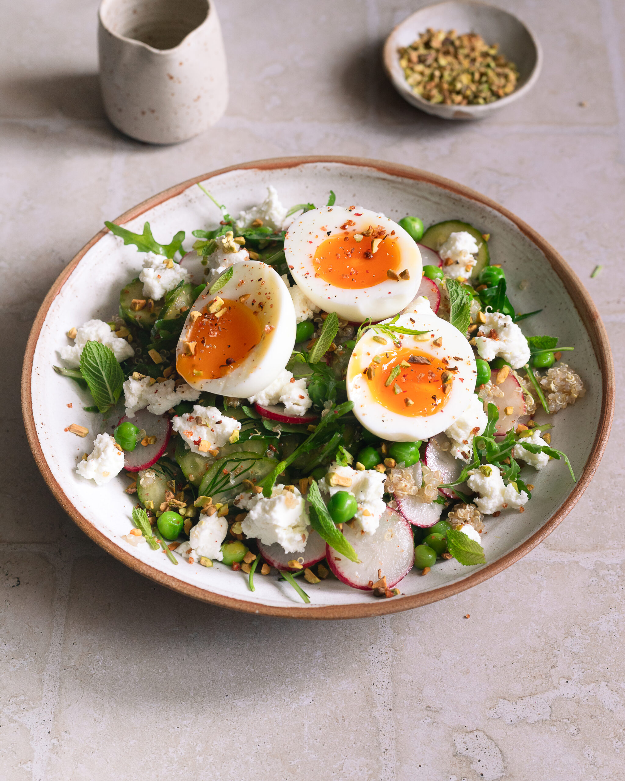 Salade de printemps au quinoa, petits pois, pickles de concombre et oeufs mollets